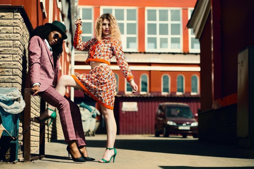 Stylish women posing in an urban alley showcasing contemporary fashion trends.